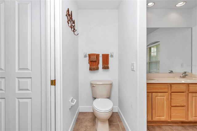 bathroom with toilet, tile patterned floors, and vanity