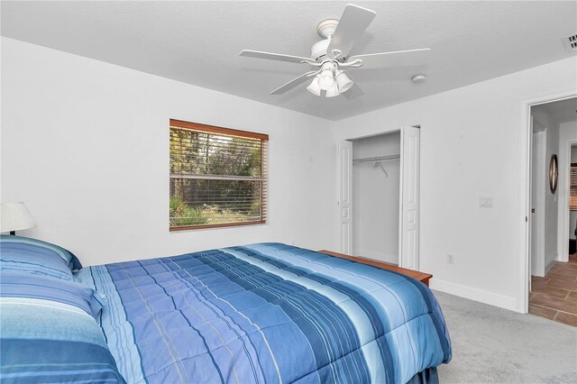 carpeted bedroom featuring ceiling fan and a closet