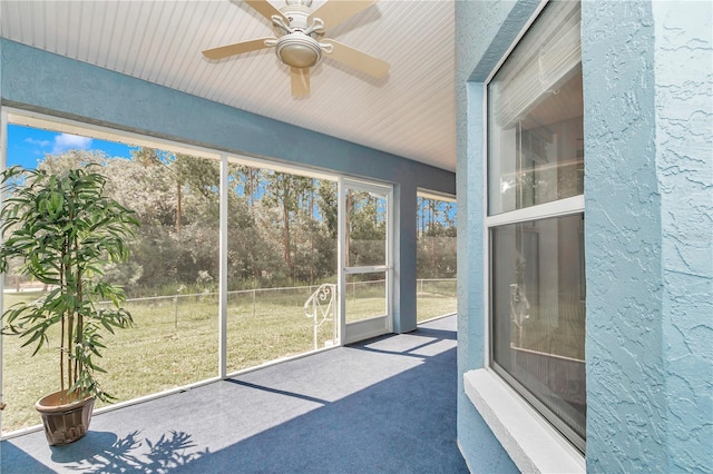 unfurnished sunroom with a ceiling fan