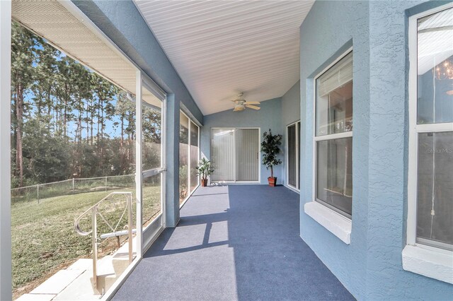 unfurnished sunroom featuring ceiling fan and lofted ceiling