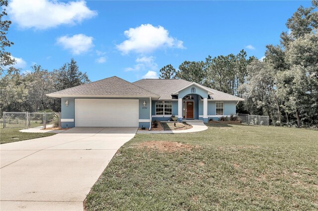 ranch-style home featuring an attached garage, fence, concrete driveway, stucco siding, and a front yard