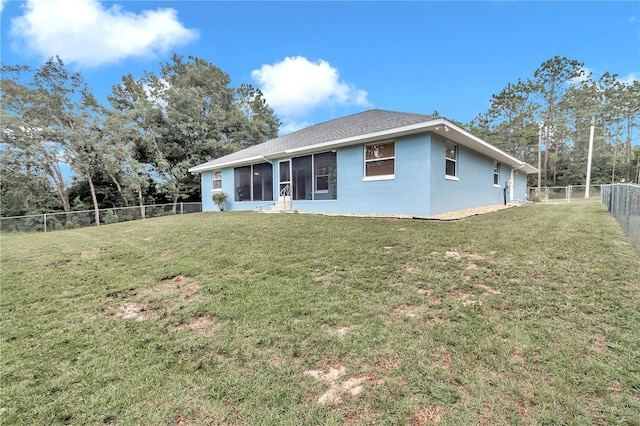 rear view of property featuring a yard, a shingled roof, a fenced backyard, and stucco siding