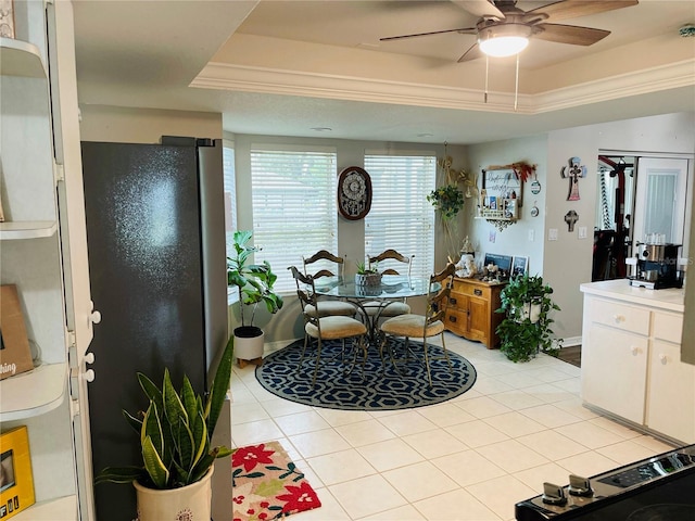 interior space featuring tile patterned flooring, ceiling fan, a raised ceiling, and vanity