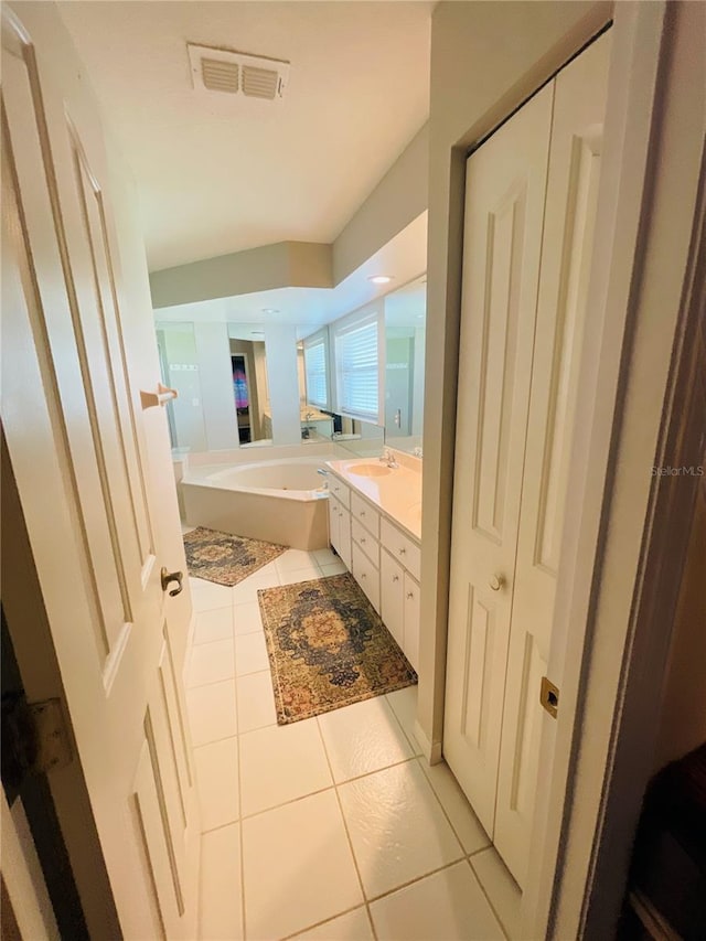 bathroom with vanity, a bathtub, and tile patterned floors