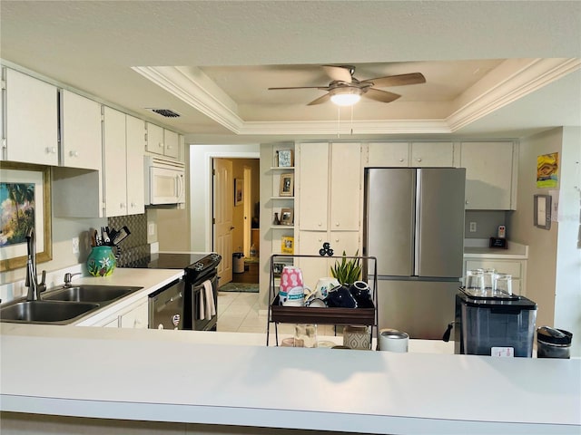 kitchen with light tile patterned floors, stainless steel appliances, sink, a tray ceiling, and ceiling fan