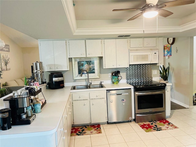 kitchen with appliances with stainless steel finishes, a raised ceiling, sink, and ceiling fan