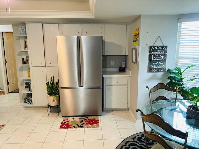 kitchen with light tile patterned floors, stainless steel refrigerator, and a healthy amount of sunlight