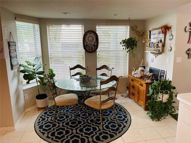 dining space with a textured ceiling and light tile patterned floors