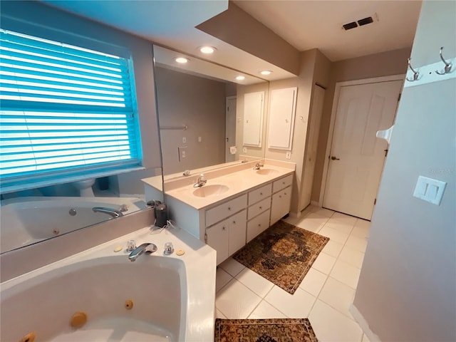 bathroom featuring a tub to relax in, vanity, and tile patterned floors