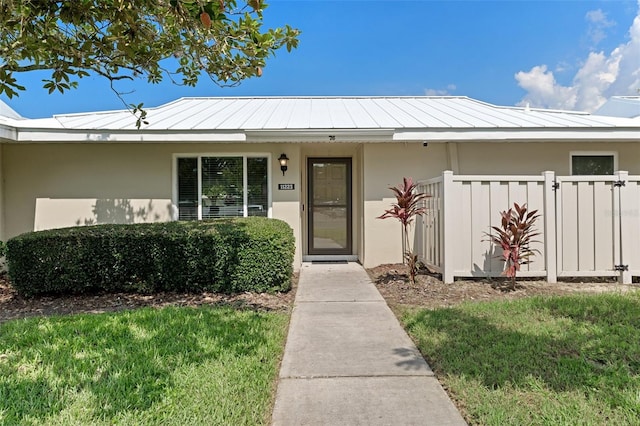 entrance to property with a lawn