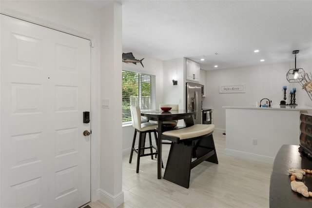 dining space with recessed lighting, a textured ceiling, and baseboards