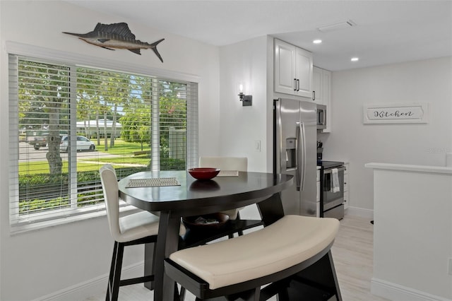 dining space featuring light wood-style flooring, baseboards, and recessed lighting