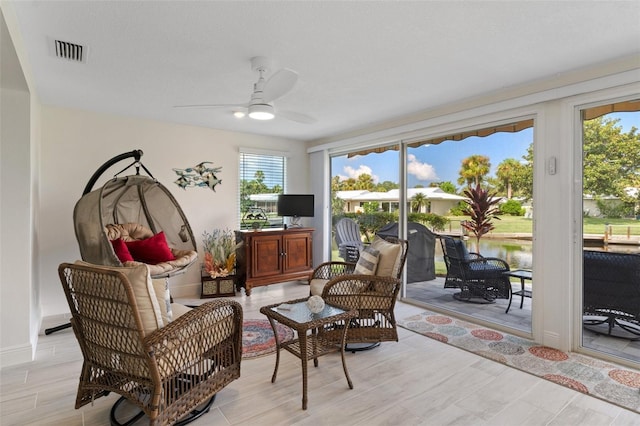 sunroom with a ceiling fan and visible vents