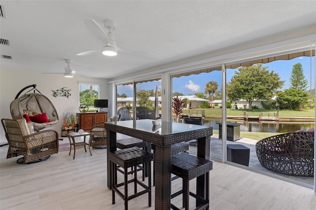 dining area featuring a textured ceiling, light hardwood / wood-style flooring, and ceiling fan