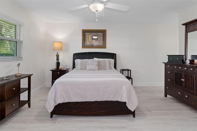 bedroom with ceiling fan, wood tiled floor, and baseboards