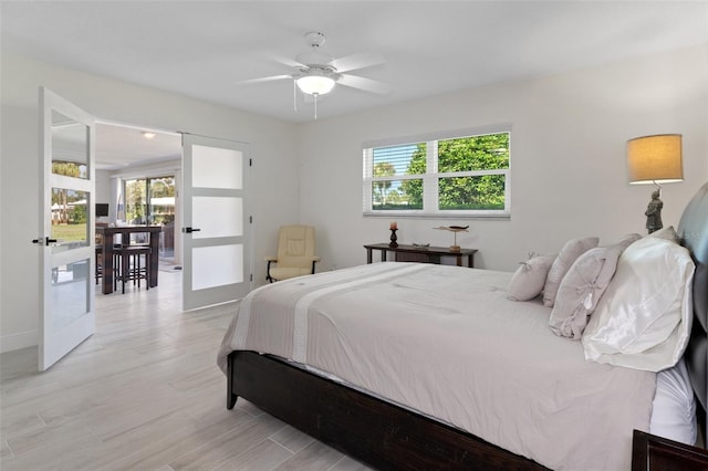 bedroom featuring ceiling fan, french doors, and light wood-type flooring