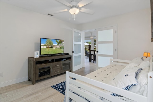 bedroom featuring french doors, visible vents, ceiling fan, light wood-type flooring, and baseboards