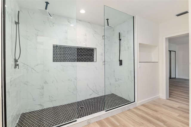 bathroom with wood-type flooring and an enclosed shower