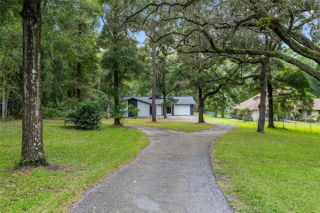 view of front of house with an outdoor structure, a garage, and a front lawn