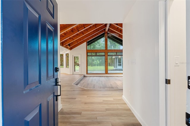 interior space with light hardwood / wood-style floors, wooden ceiling, and vaulted ceiling with beams