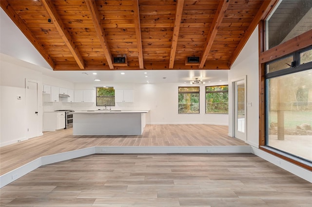 kitchen with tasteful backsplash, range with two ovens, white cabinets, a kitchen island, and wood ceiling