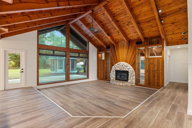 unfurnished living room featuring light hardwood / wood-style flooring, wood ceiling, high vaulted ceiling, beam ceiling, and a fireplace