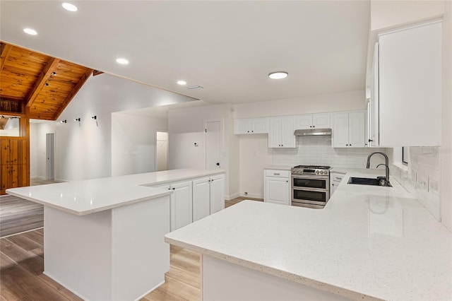 kitchen with double oven range, light hardwood / wood-style floors, tasteful backsplash, sink, and wooden ceiling