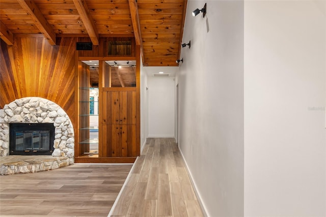 hall featuring wood ceiling, light hardwood / wood-style flooring, wooden walls, and lofted ceiling