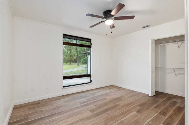 unfurnished bedroom featuring ceiling fan, a closet, and hardwood / wood-style floors