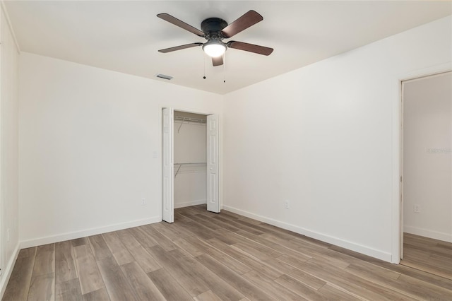 unfurnished bedroom with ceiling fan, light hardwood / wood-style flooring, and a closet