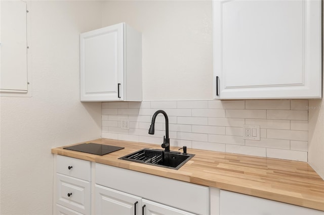 kitchen with sink, tasteful backsplash, and white cabinets