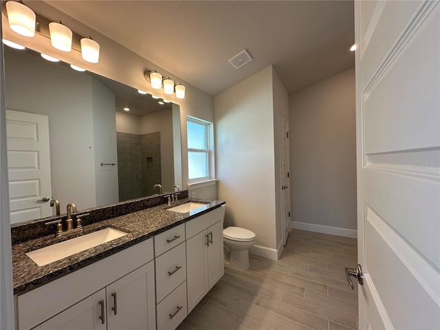 full bath featuring double vanity, a shower stall, visible vents, and a sink