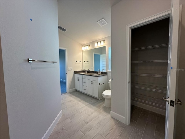 full bathroom featuring visible vents, toilet, wood finished floors, vaulted ceiling, and vanity