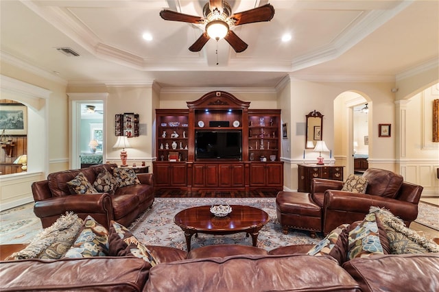 living room with ceiling fan, a raised ceiling, hardwood / wood-style floors, and crown molding