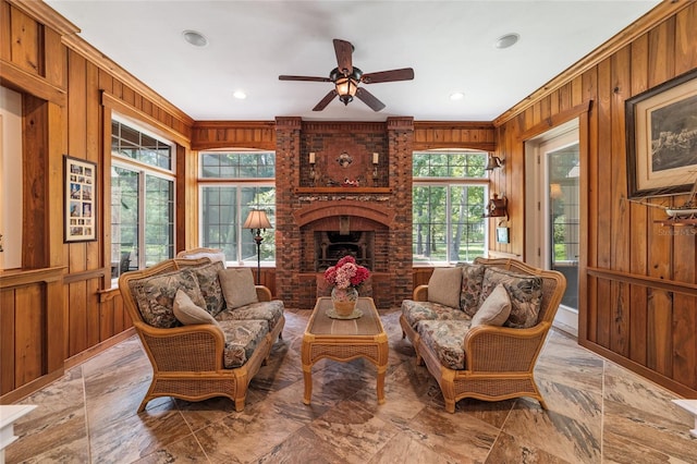 living room with brick wall, wooden walls, light tile patterned floors, ceiling fan, and a brick fireplace