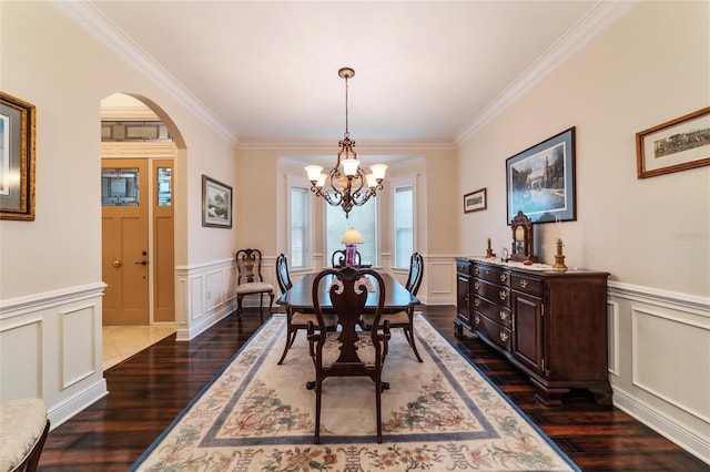 dining space featuring ornamental molding, an inviting chandelier, and dark hardwood / wood-style floors