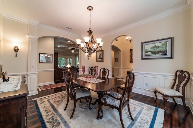 dining room featuring crown molding, dark wood-type flooring, and decorative columns