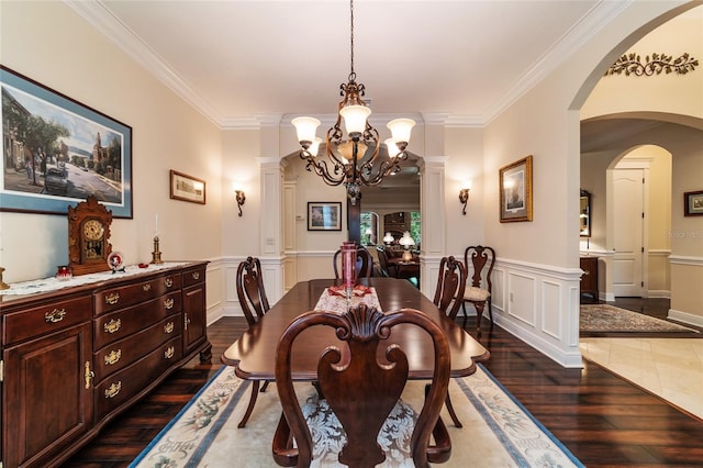 dining area featuring crown molding, ornate columns, dark hardwood / wood-style flooring, and an inviting chandelier