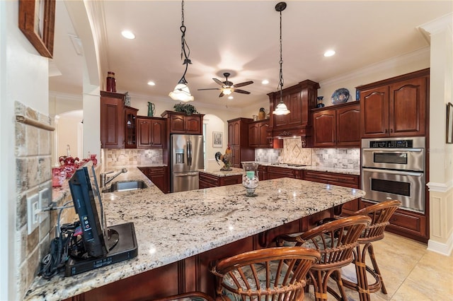 kitchen with ceiling fan, backsplash, sink, decorative light fixtures, and stainless steel appliances