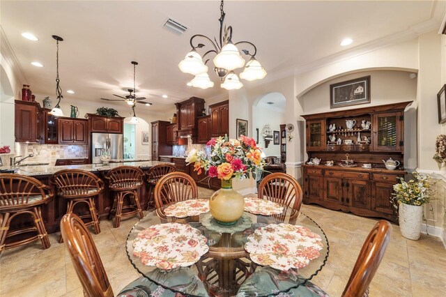 dining room featuring ornamental molding, ceiling fan with notable chandelier, and light tile patterned floors