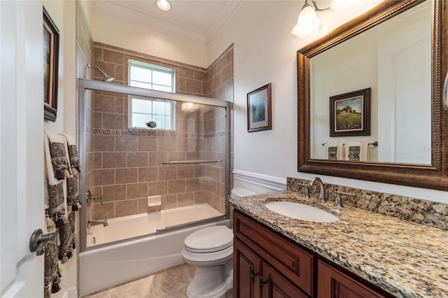 full bathroom with ornamental molding, tile patterned floors, shower / bath combination with glass door, vanity, and toilet