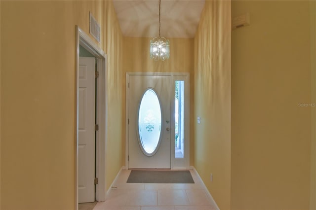 entryway featuring a notable chandelier and light tile patterned flooring