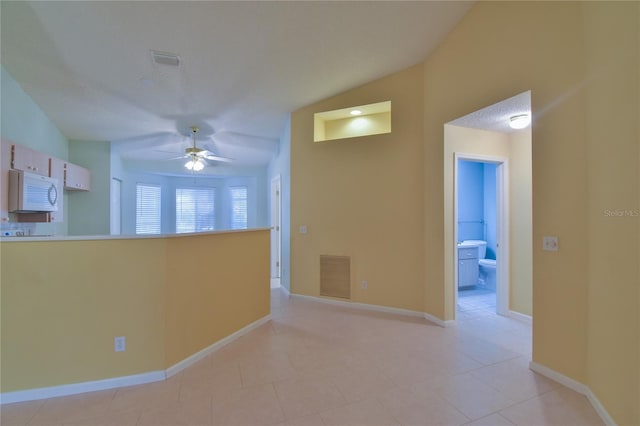 corridor with lofted ceiling and light tile patterned flooring