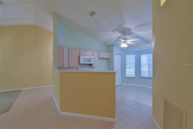 kitchen featuring vaulted ceiling, white appliances, light brown cabinets, light tile patterned floors, and ceiling fan