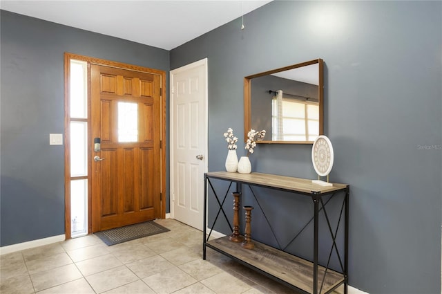 foyer entrance featuring a healthy amount of sunlight, baseboards, and tile patterned floors