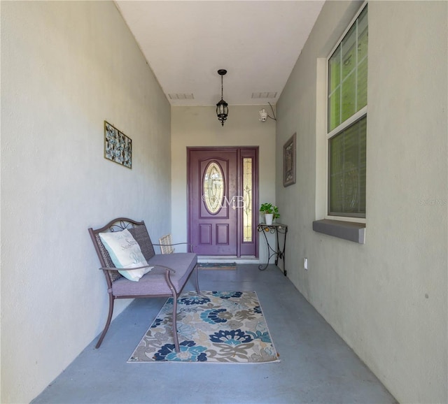 doorway to property with visible vents and stucco siding