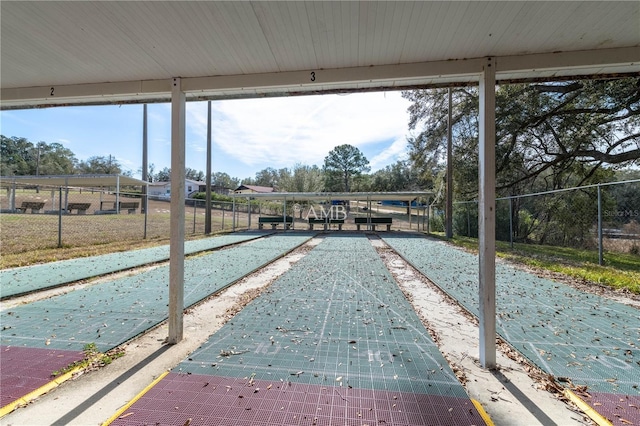 view of community with fence and shuffleboard