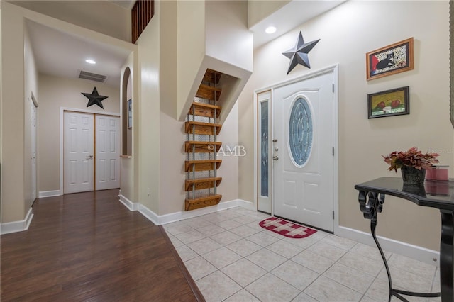 foyer featuring light tile patterned floors, baseboards, visible vents, stairs, and recessed lighting