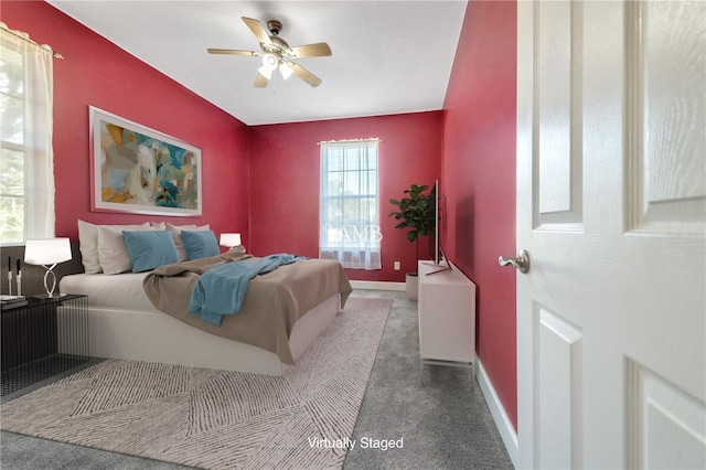 carpeted bedroom with ceiling fan and baseboards