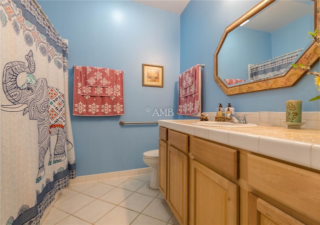 full bathroom with toilet, tile patterned flooring, baseboards, and vanity